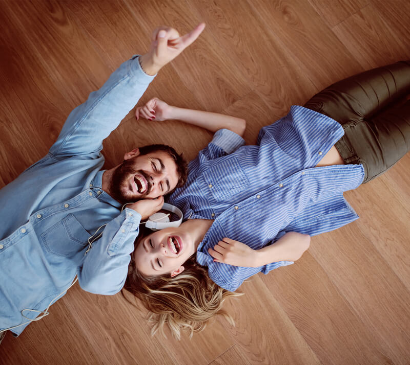 male and female happy laying on newly installed floors